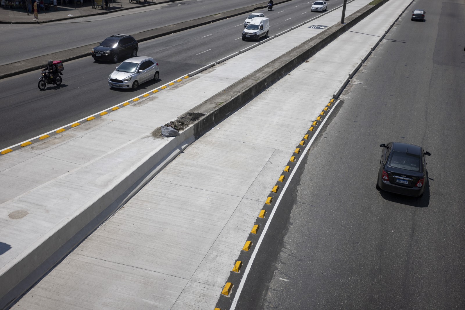 Segregação da pista seletiva da Avenida Brasil é feita com blocos de concreto e, nos chamados "trechos de escape", são usadas "tartarugas" - úteis para ônibus deixarem a pista caso um coletivo enguice à sua frente, por exemplo — Foto: Márcia Foletto / Agência O Globo