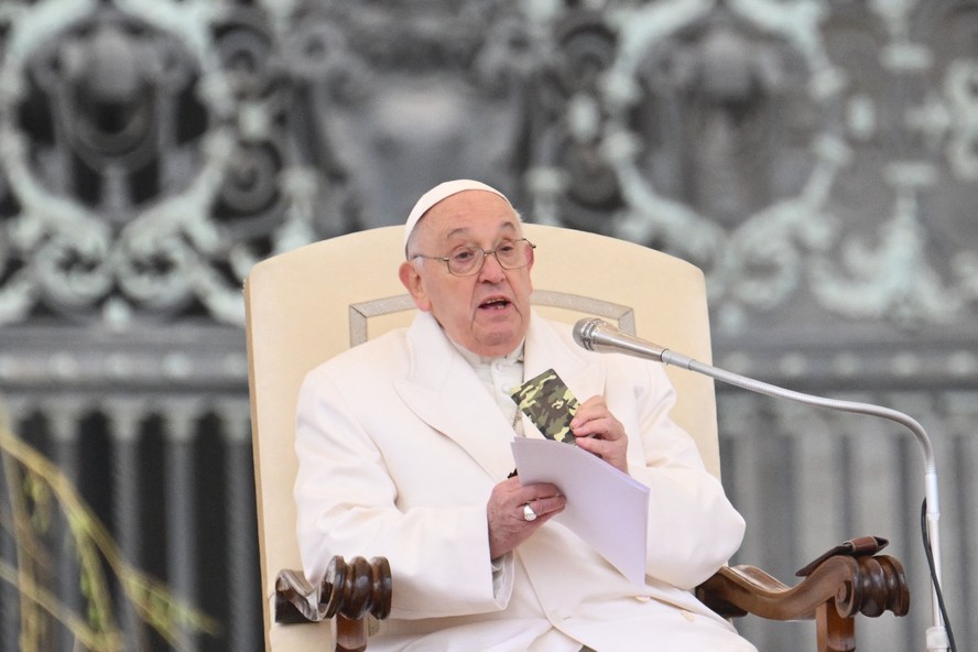 Papa Francisco segura um Novo Testamento que pertencia a um soldado morto na Ucrânia durante sua audiência geral semanal na Praça de São Pedro, no Vaticano