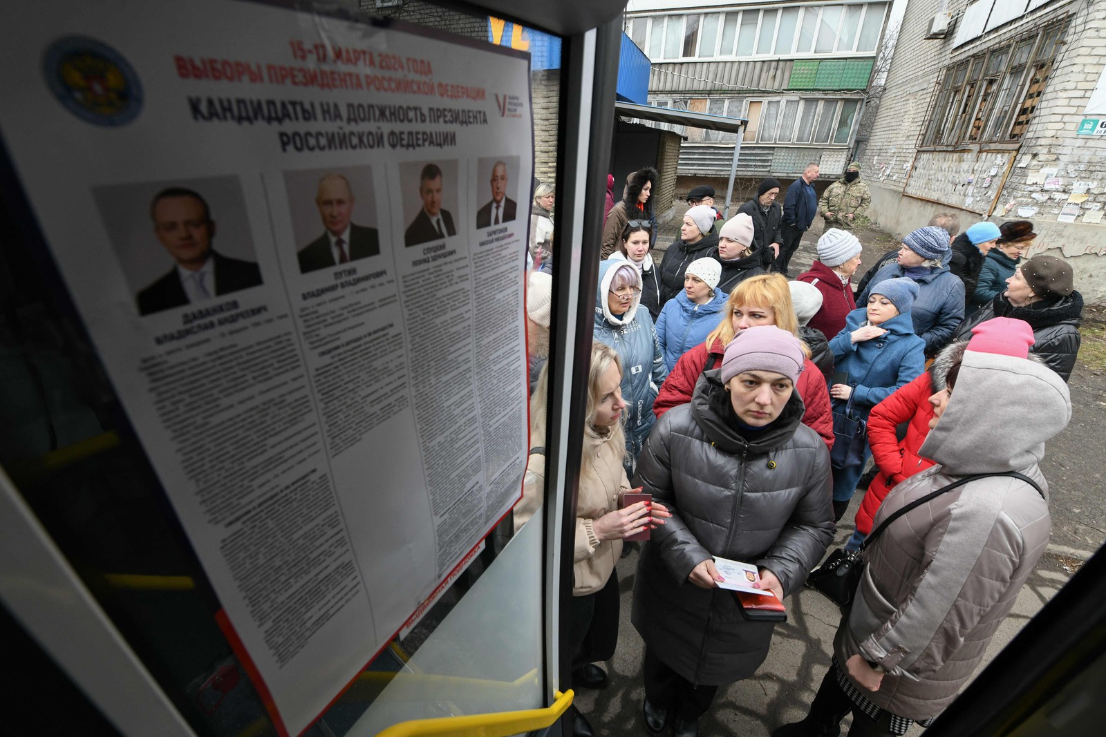 Eleitores fazem fila do lado de fora de um ônibus transformado em seção eleitoral em Makiivka, região de Donetsk, na Ucrânia controlada pela Rússia, em 17 de março de 2024 — Foto: AFP