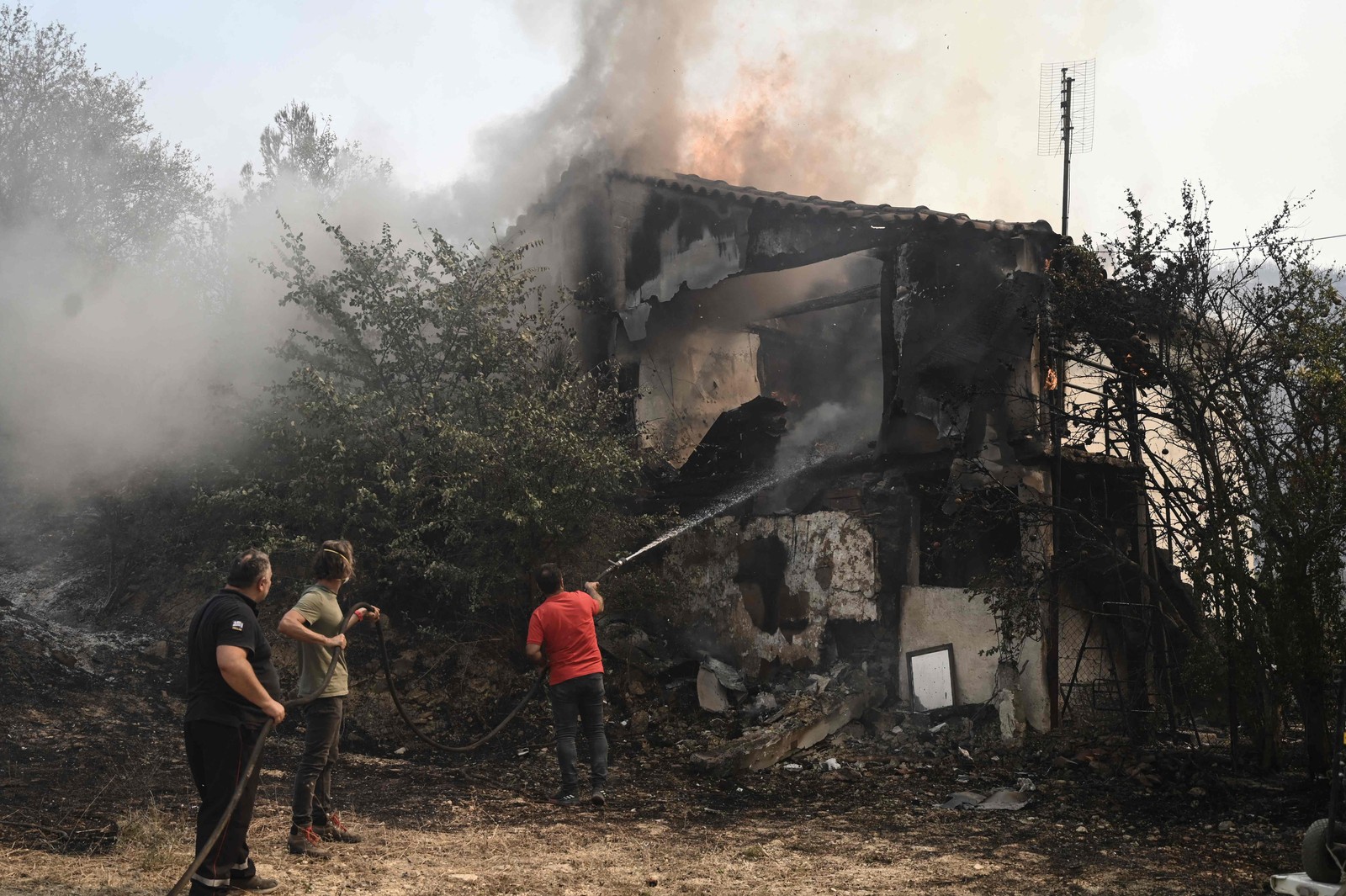 Moradores apagam um incêndio em Avanta, perto de Alexandrópolis, norte da Grécia, em 22 de agosto de 2023. — Foto: Sakis MITROLIDIS / AFP