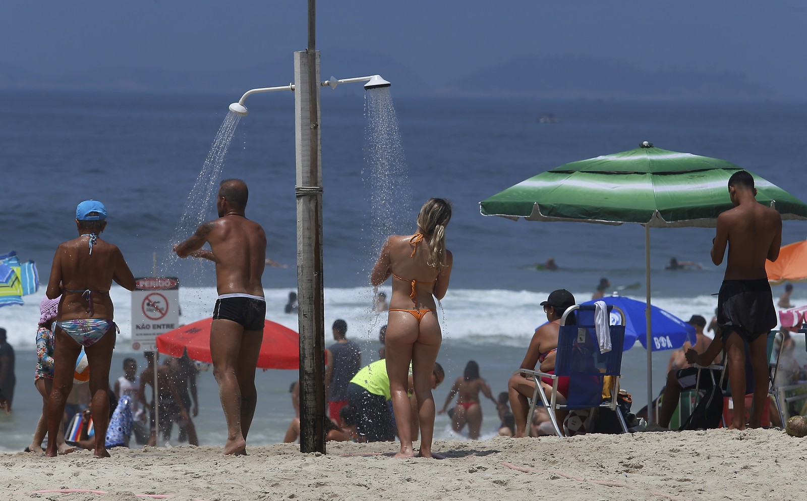 Um sol, e chuveiro, pra cada um. Sensação térmica chegou a 44 graus às 9h40 — Foto: Fabiano Rocha / Agência O Globo