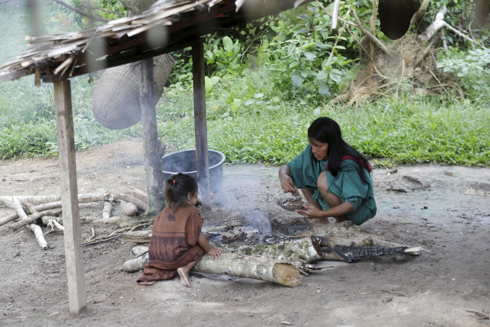 Família ashaninka prepara o café da manhã com mandioca e carne de veado — Foto: Domingos Peixoto / Agência O Globo
