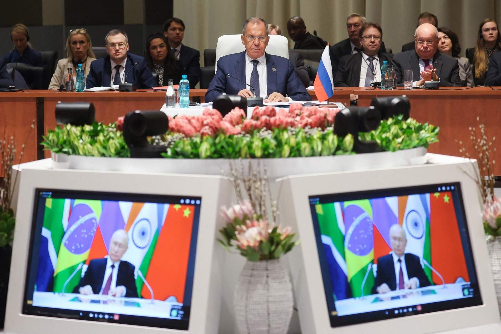 O Ministro das Relações Exteriores da Rússia, Sergei Lavrov, ouve o presidente da Rússia, Vladimir Putin, enquanto ele faz seus comentários por meio de um link de vídeo durante a Cúpula do BRICS de 2023 em Joanesburgo, África do Sul — Foto: AFP / MINISTÉRIO EXTERIOR DA RÚSSIA