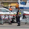 Bombeiros e agentes da Defesa Civil são fotografados ao lado de sacos contendo os corpos de migrantes que morreram após o naufrágio de uma embarcação que tentava cruzar o Canal da Mancha em direção à Inglaterra - Denis Charlet / AFP