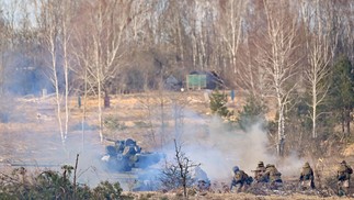 Coberto com rede de camuflagem, um caminhão do exército ucraniano equipado com uma arma antiaérea transita por entre as árvores secas na zona de exclusão — Foto: Sergei Supinsky / AFP