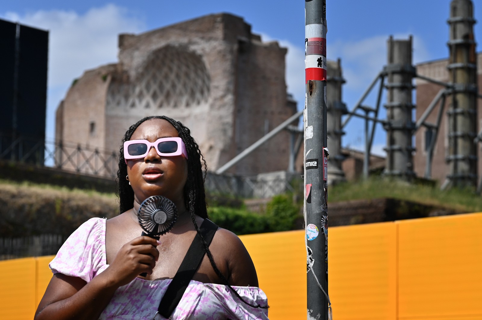 Uma mulher se refresca com um miniventilador em Roma, em 14 de julho de 2023, enquanto a Itália é atingida por uma onda de calor — Foto: AFP