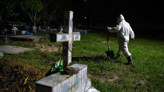 Coveiro com roupas de proteção no cemitério municipal Recanto da Paz, durante o enterro de uma vítima da COVID-19, na cidade de Breves, a sudoeste da ilha do Marajó, no Pará — Foto: TARSO SARRAF / AFP