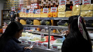 Mulheres compram queijo em uma banca do Mercado Central de Buenos Aires. Argentina tem uma das maiores taxas de inflação do mundo. — Foto: Luis ROBAYO / AFP