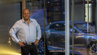 Gil Dezer, o empreendedor por trás do Porsche Design Tower e do Bentley Residences, posa em frente a um carro estacionado no “dezervator”, elevador que leva motorista e veículo até a residência, onde o veículo  pode ser visto da unidade através de uma parede de vidro — Foto: Scott Baker/The New York Times