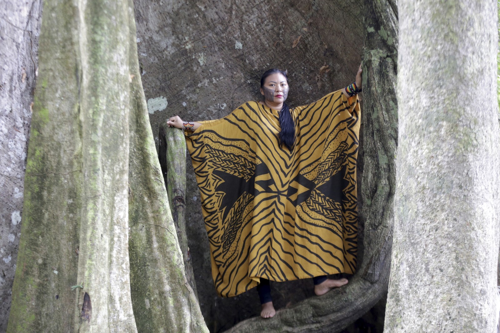 Elaine Pyãko na base de uma samaúma gigantesca. Ela pertence ao yawanawá  e se casou com Francisco Pyãko, com quem tem o filho Franscico - Foto: Domingos Peixoto / Agência O Globo