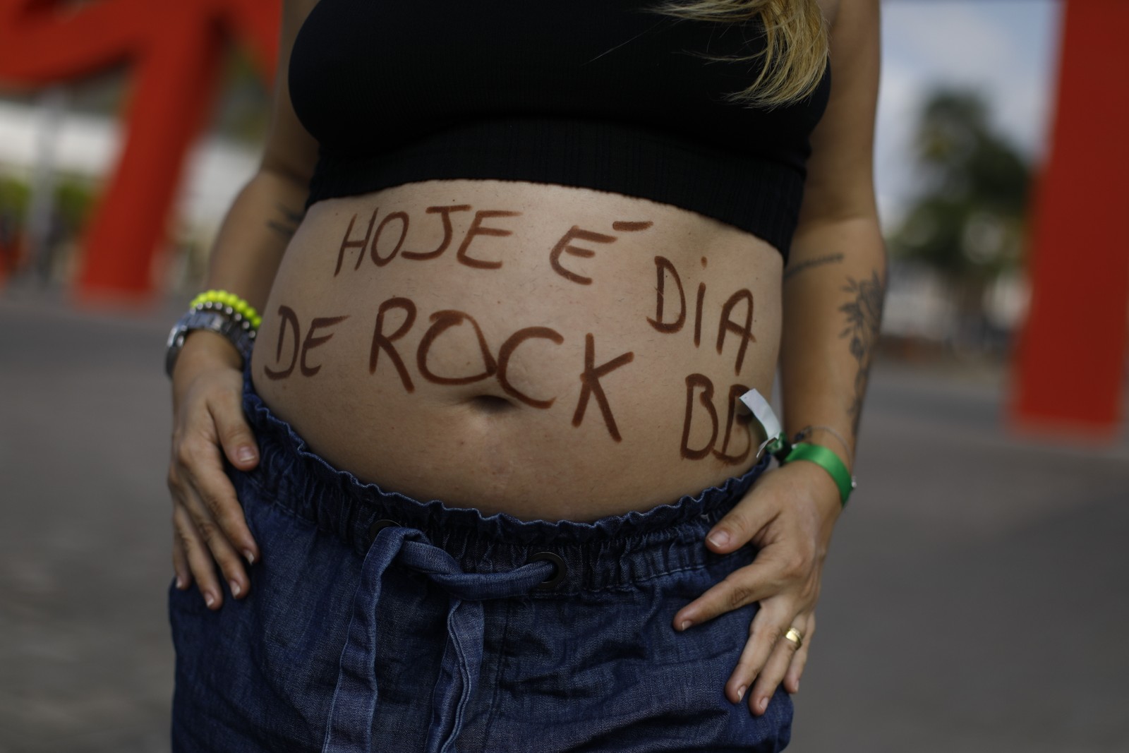 Apesar da mensagem no barrigão da professora Natasha Guzenski, 33, hoje é o dia de rap e eletrônico no Rock in Rio — Foto: Brenno Carvalho/Agência O Globo
