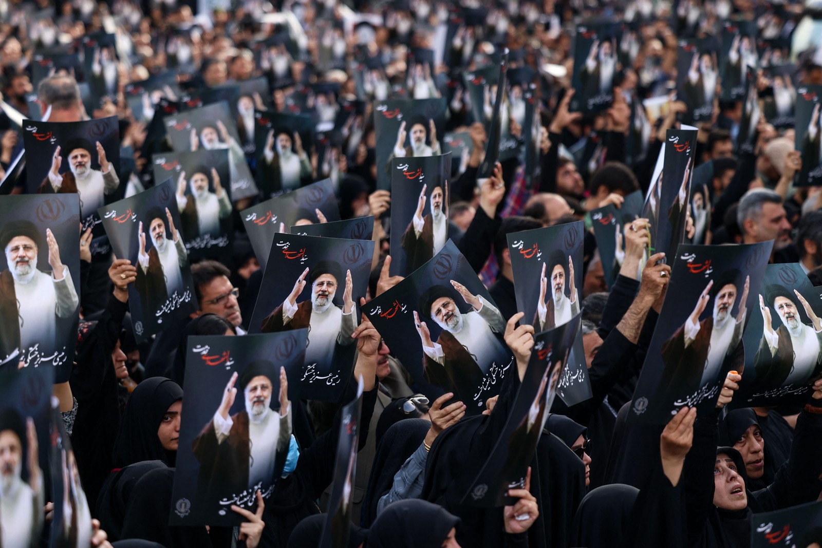 Iranianos se reúnem na Praça Valiasr, no centro de Teerã, para lamentar a morte do presidente Ebrahim Raisi, do ministro das Relações Exteriores Hossein Amir-Abdollahian e de sete outras pessoas em um acidente de helicóptero. — Foto: ATTA KENARE/AFP