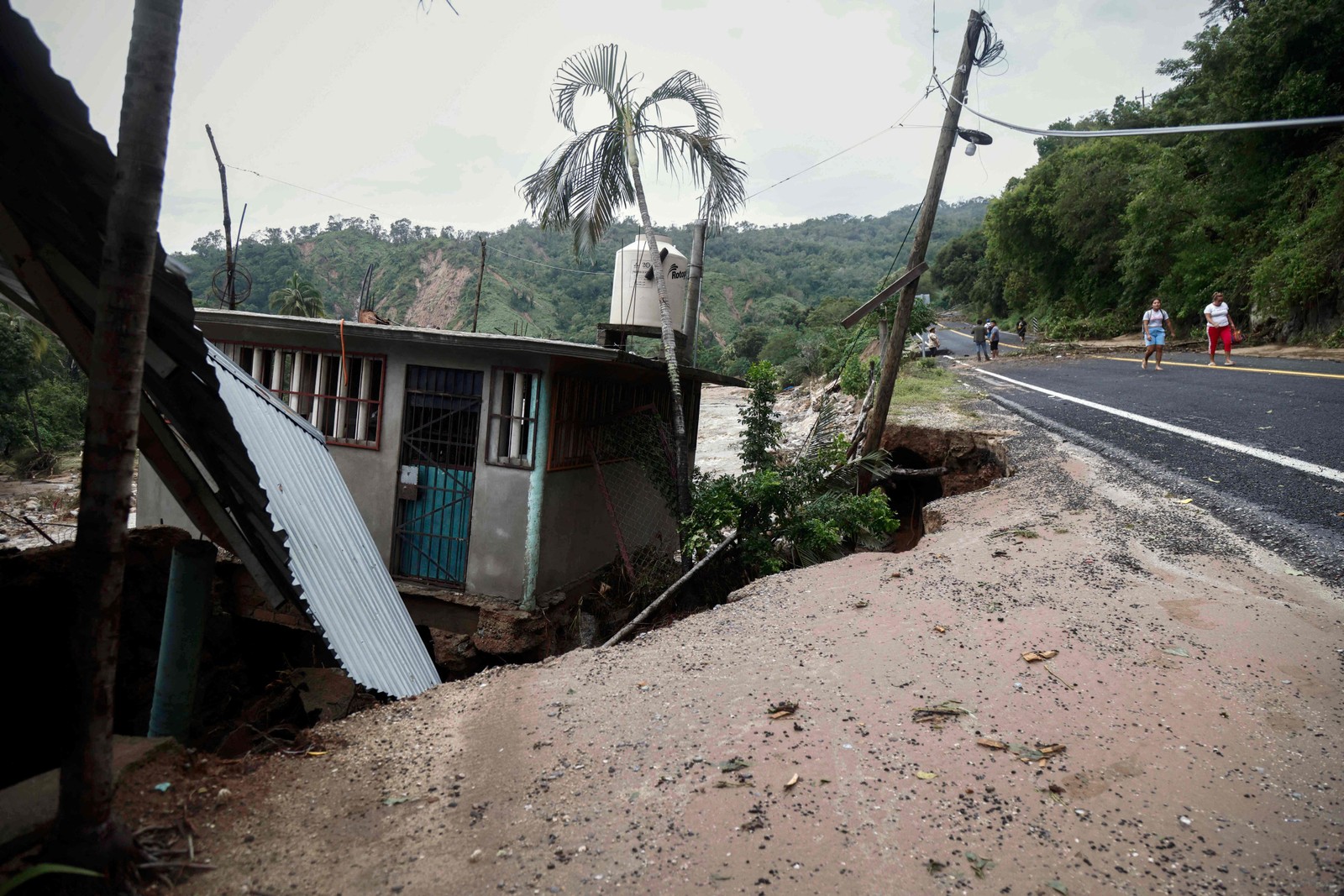 Foto de uma casa em um terreno que cedeu na comunidade Kilometro 42, próximo a Acapulco, estado de Guerrero, México, após a passagem do furacão Otis — Foto: RODRIGO OROPEZA/AFP