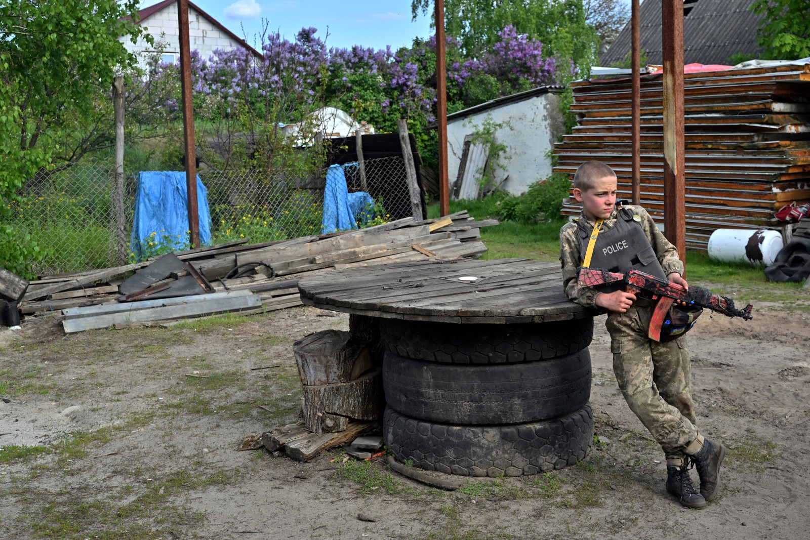 Crianças usam coletes à prova de balas feitos em casa durante 'brincadeiras' de guerra — Foto: Sergei Supinsky/AFP