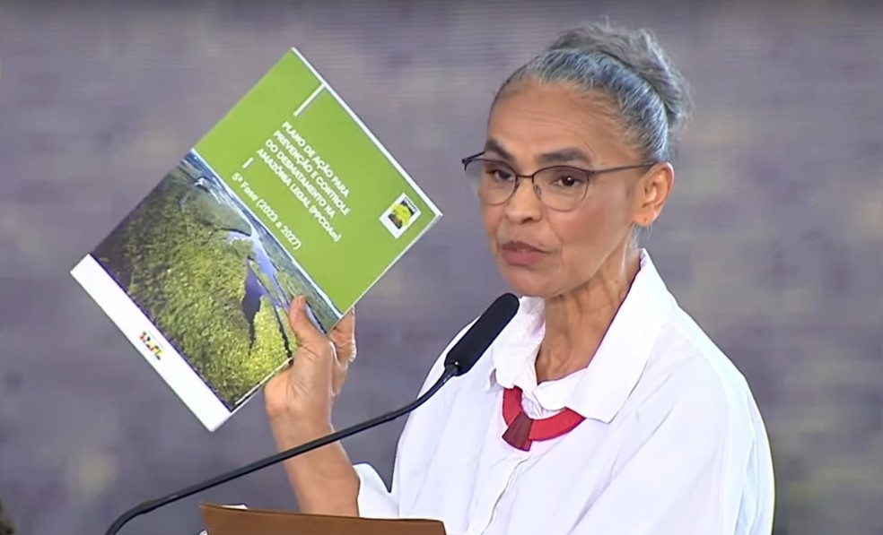 Marina Silva segura exemplar do PPCDAm, o plano de combate ao desmatamento da Amazônia — Foto: TV Brasil/reprodução