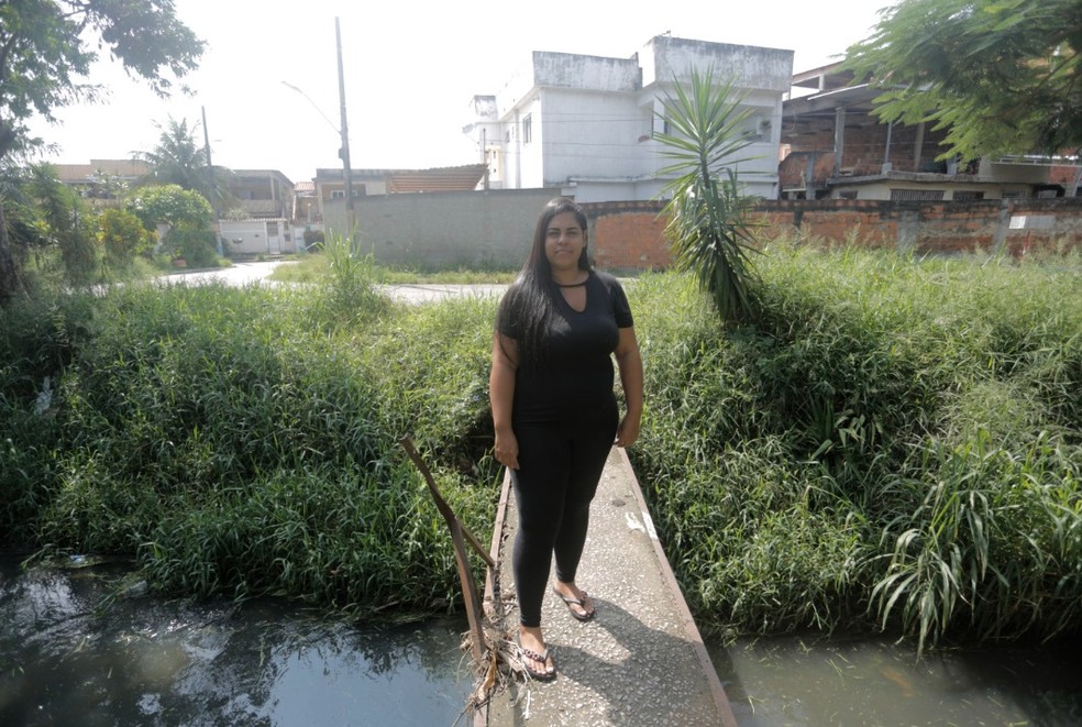 A manicure Marian Marques, de 24 anos, moradora de Mesquita, reclama do mau cheiro do rio perto de sua casa — Foto: Fabio Rossi/Agência O Globo