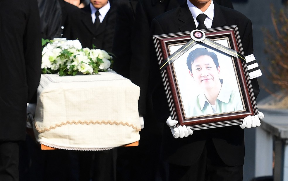 Filho mais velho de Lee Sun-kyun segura foto do pai em velório do ator sul-coreano — Foto: Korea Pool/AFP