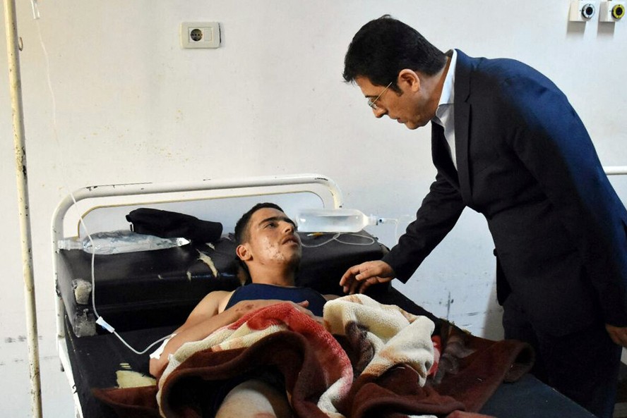 Ministro da Saúde da Síria, Hassan Muhammad al-Ghobash, visita feridos no ataque com drone a academia militar em Homs