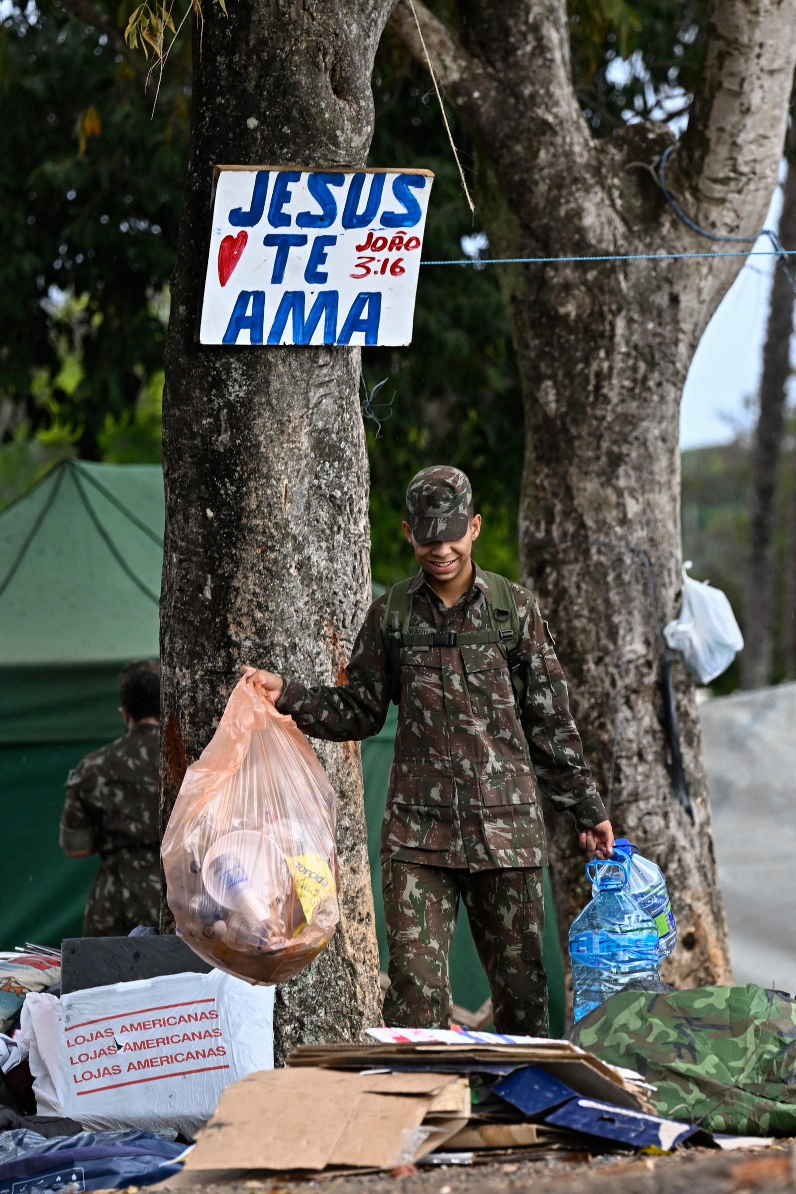 Soldado ajuda a desmantelar o acampamento montado por apoiadores do ex-presidente Jair Bolsonaro, em frente ao quartel-general do Exército em Brasília. — Foto: MAURO PIMENTEL/AFP