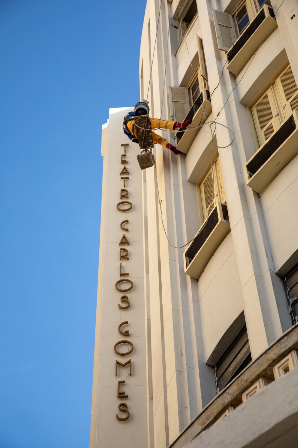 Funcionário dá os últimos retoques na fachada do Teatro Carlos Gomes, após dois anos em reforma — Foto: Ana Branco/Agência O Globo