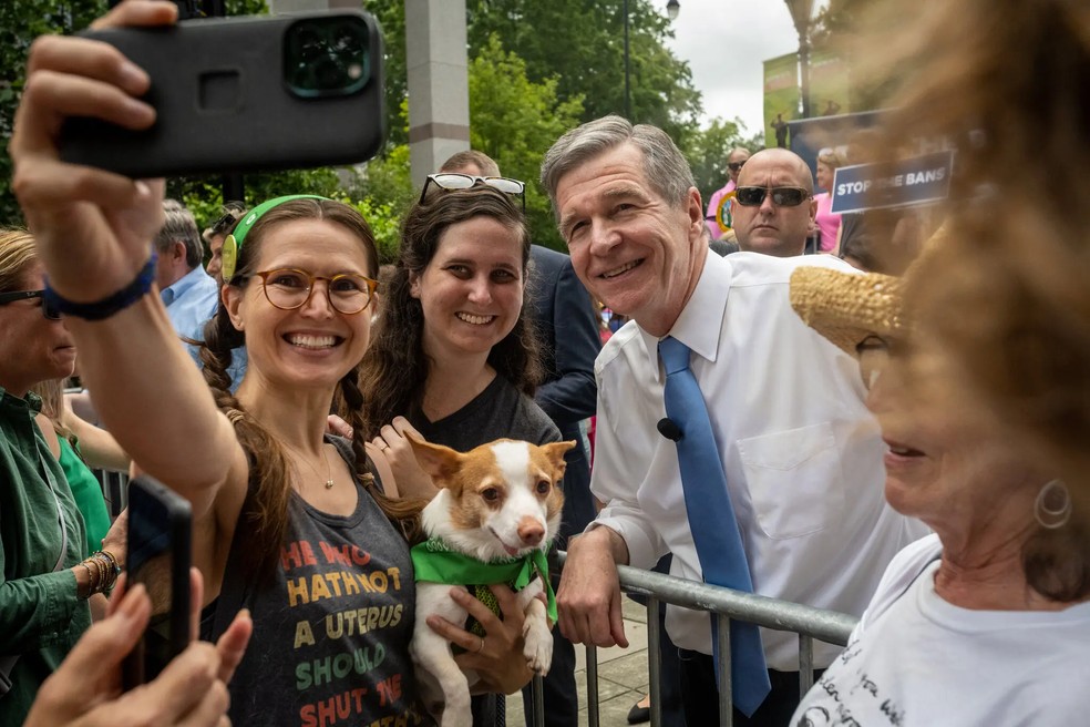 Roy Cooper, governador democrata da Carolina do Norte, posa para fotos durante passeata pró-direito ao aborto  — Foto: Kate Medley/NYT