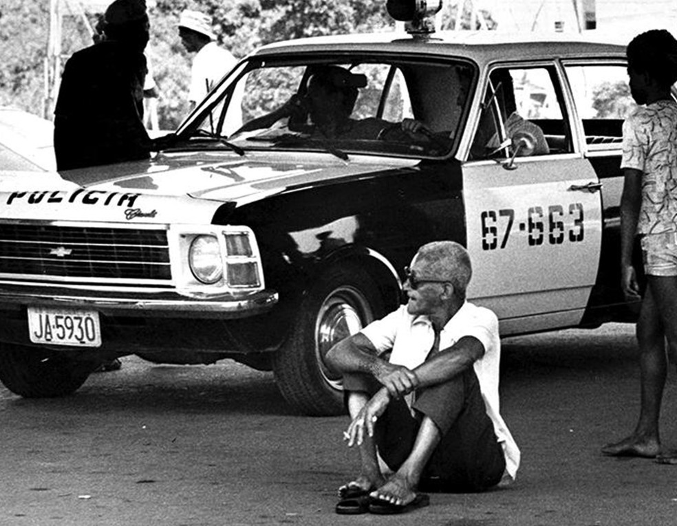 O compositor Cartola senta ao chão após ser agredido pela polícia — Foto: Eurico Dantas / 1976