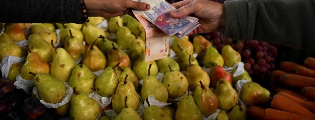 Um homem compra frutas e verduras no Mercado Central de Buenos Aires. Em meio a crise, o país criou nova cédula de 2000 pesos argentinos. — Foto: Luis ROBAYO / AFP