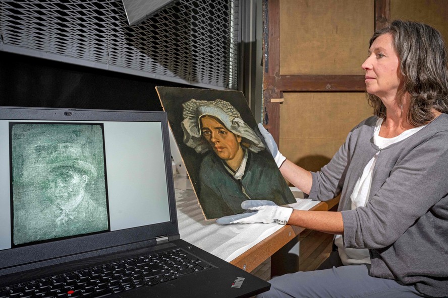 Uma foto divulgada pelas Galerias Nacionais da Escócia em 14 de julho de 2022 mostra Lesley Stevenson vendo 'Cabeça de uma mulher camponesa' ao lado de uma imagem de raio-X de um autorretrato oculto do pintor holandês Vincent Van Gogh em Edimburgo