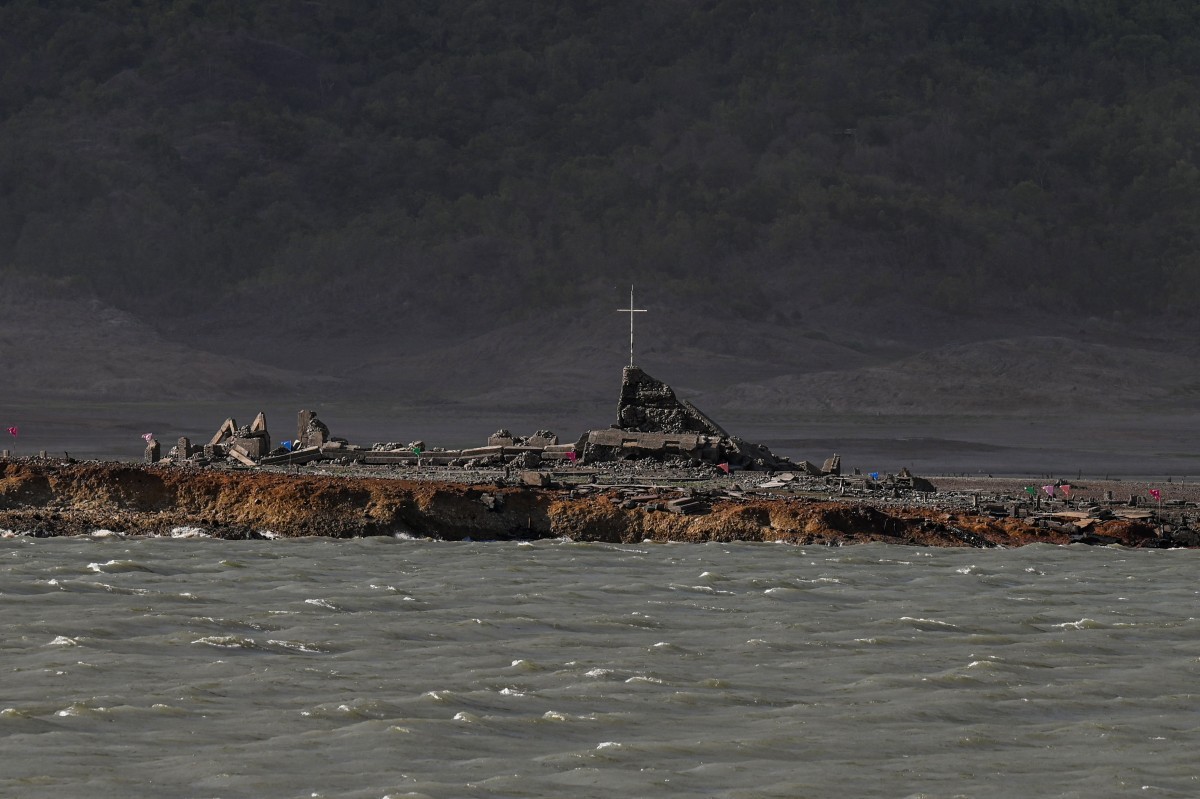 Vestígios da cidade centenária de Pantabangan ressurgiram no norte das Filipinas após o nível da água da barragem baixar em meio a uma seca que assola muitas partes do país — Foto: JAM STA ROSA / AFP