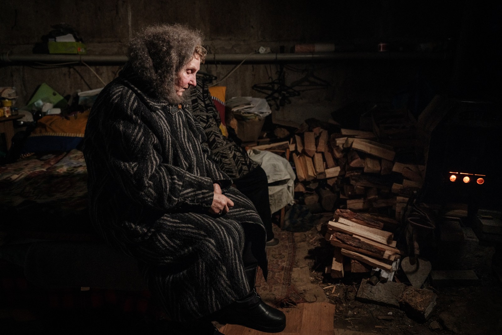 Lyubov Stepanova, de 71 anos, que mora no porão de seu apartamento com cerca de vinte outras pessoas, olha para um fogão, na cidade de Avdiivka — Foto: YASUYOSHI CHIBA / AFP - 08/02/2023