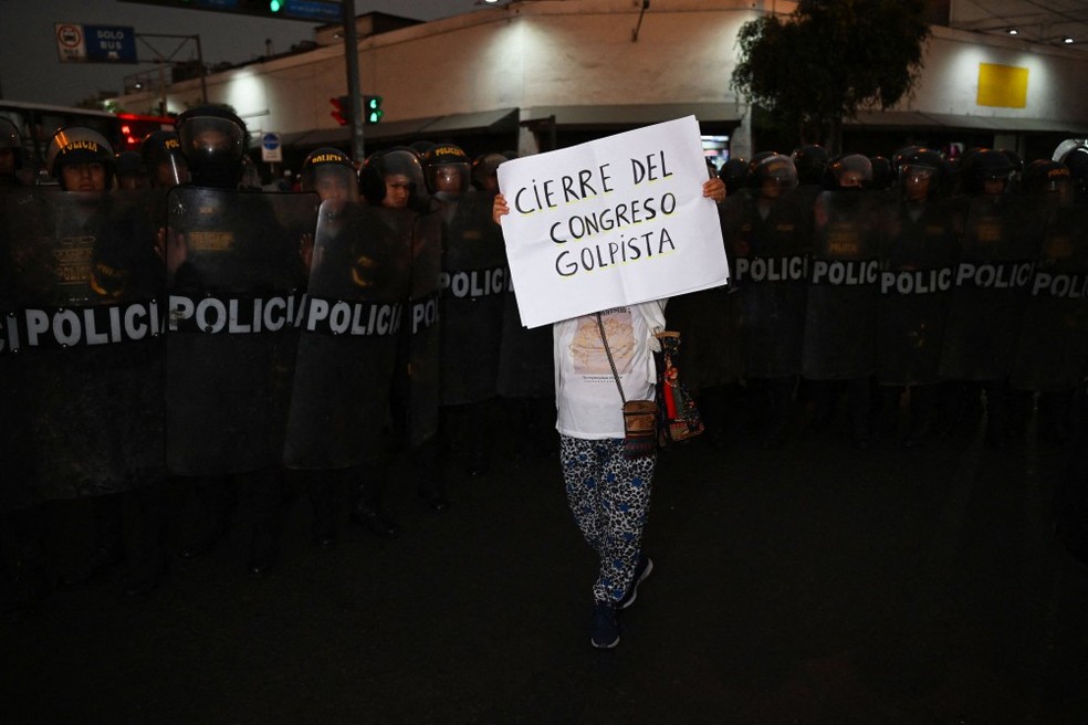 Manifestante segura um cartaz pedindo o fim do "Congresso golpista" no Peru, durante manifestação na capital, Lima — Foto: Ernesto Benavides / AFP