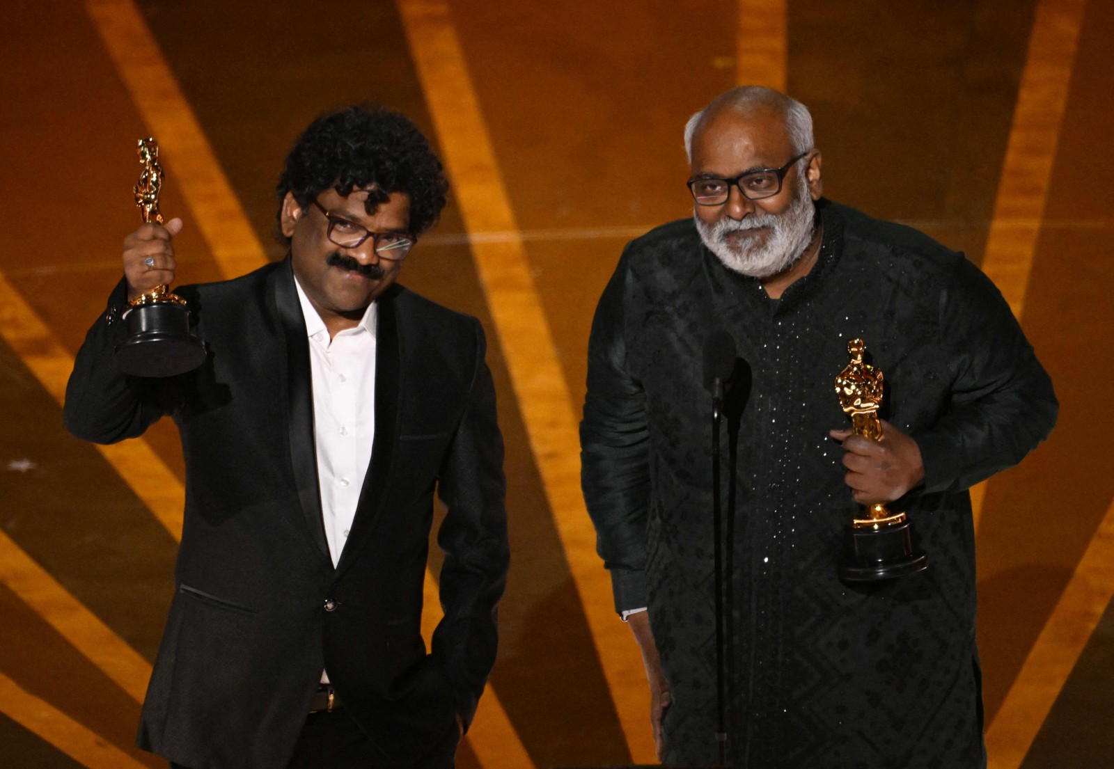 O compositor indiano M.M. Keeravaani e o músico indiano Chandrabose recebem o Oscar de Melhor Canção Original por "Naatu Naatu", do filme “RRR: revolta, rebelião, revolução” — Foto: Patrick T. Fallon / AFP