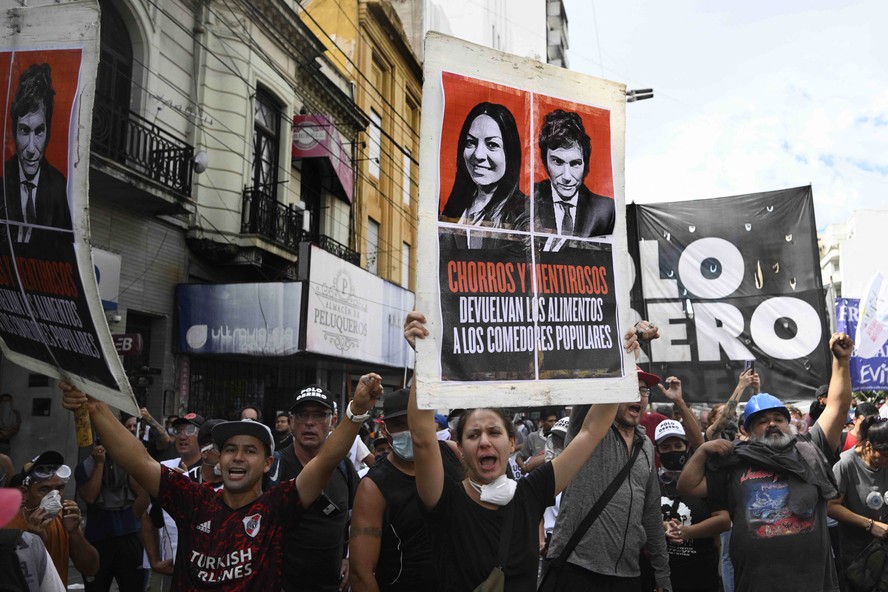 Membros de movimentos sociais gritam palavras de ordem durante um protesto contra cortes do governo do presidente Javier Milei nos setores mais vulneráveis