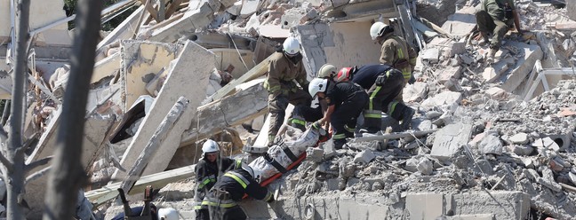 Socorristas retiram corpo de vítima de um prédio destruído após ser atingido por um ataque de mísseis na cidade ucraniana de Sergiyvka , perto de Odessa — Foto: Oleksandr GIMANOV / AFP