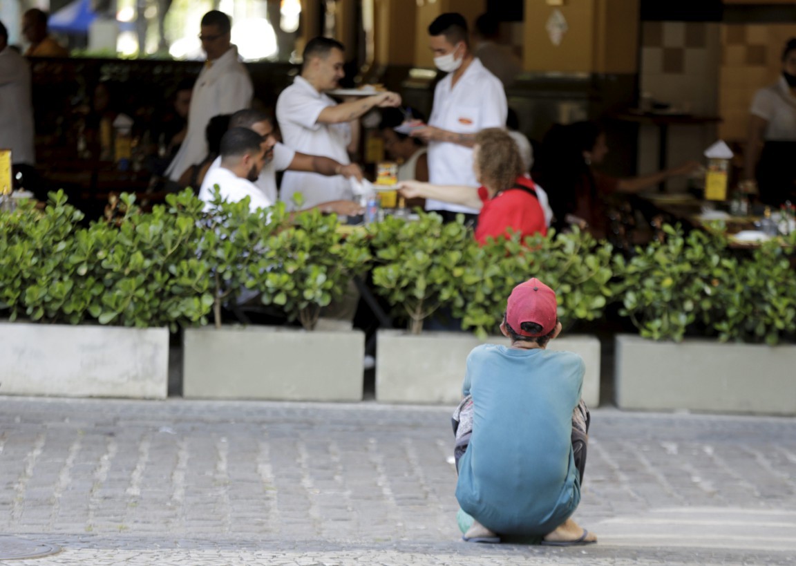 Morador de rua espera por restos de comida que clientes de um restaurante, na Cinelândia, poderão deixar: a falta de comida faz parte do cotidiano de 15,9% da população fluminense — Foto: Domingos Peixoto / Agência O Globo