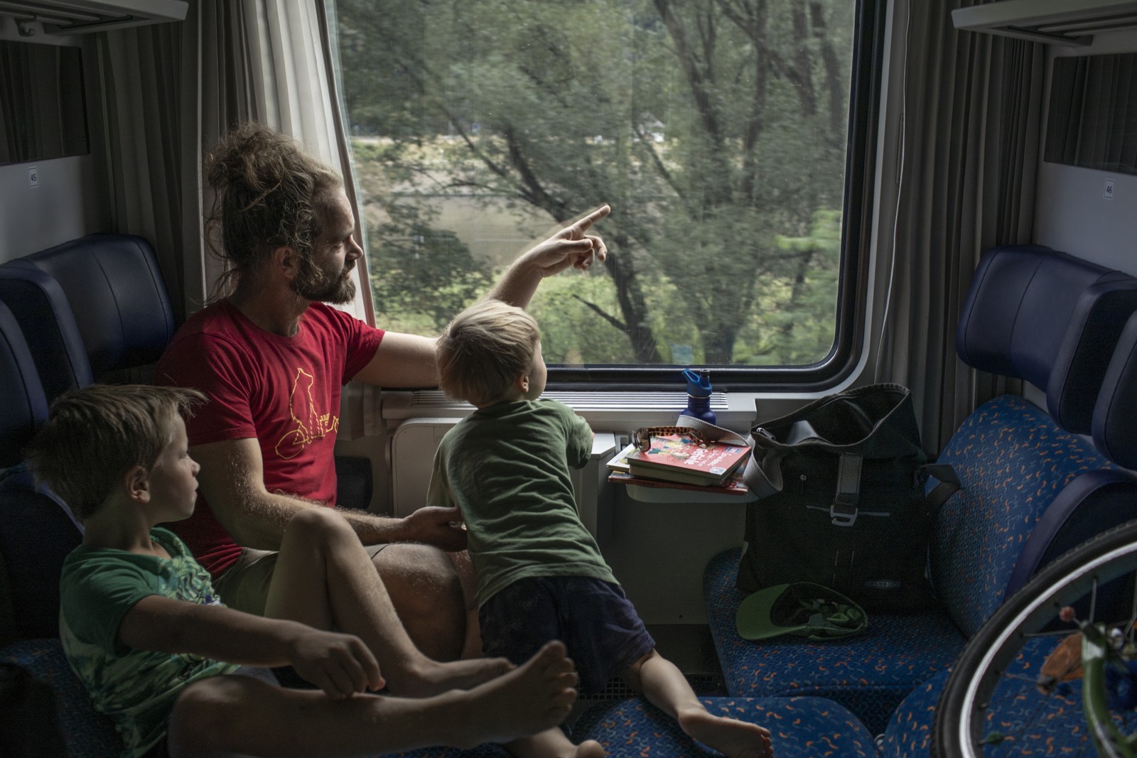 Sebastian Kaiser e seus filhos Reuel, 8, e Ilja, 4, andam de trem com destino a Praga e observam a paisagem que passa em algum lugar da Alemanha — Foto: Emile Ducke/The New York Times
