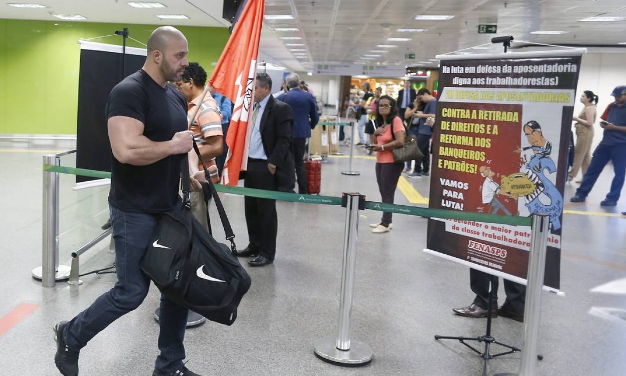 A favor da reforma da Previdência, Daniel desembarca, no Aeroporto Juscelino Kubitscheck, em Brasília, e encontra manifestação contra o projeto — Foto: Jorge William/Agência O Globo