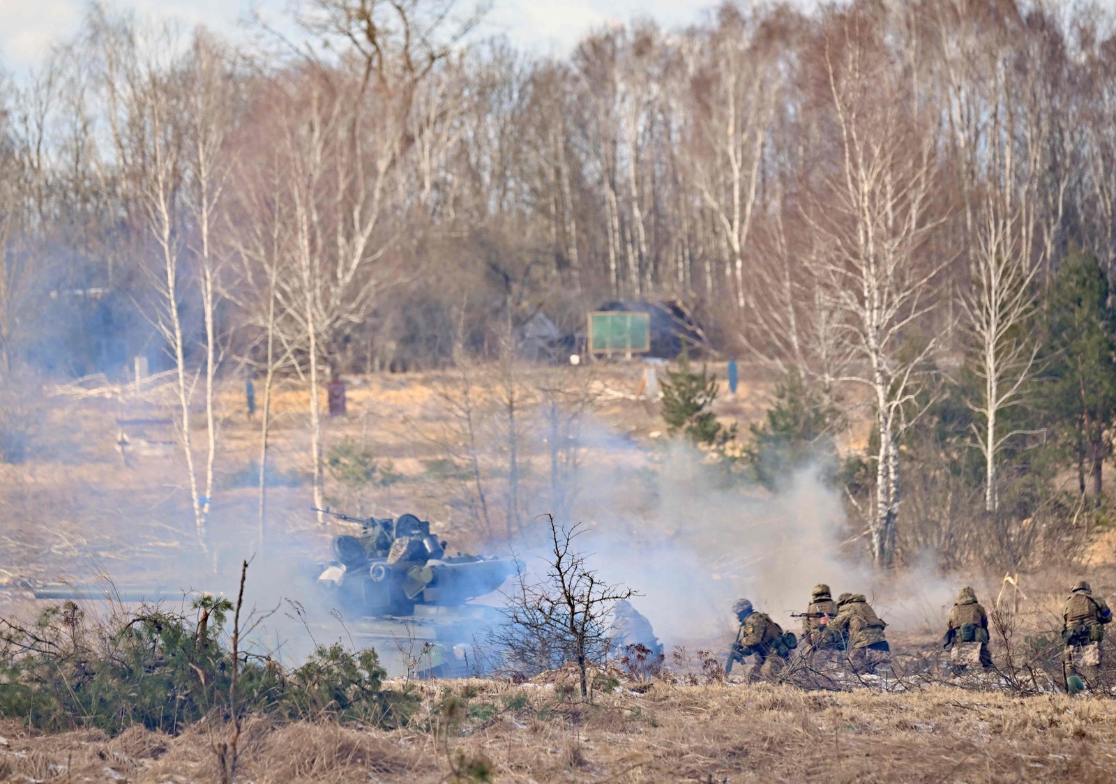 Coberto com rede de camuflagem, um caminhão do exército ucraniano equipado com uma arma antiaérea transita por entre as árvores secas na zona de exclusão — Foto: Sergei Supinsky / AFP