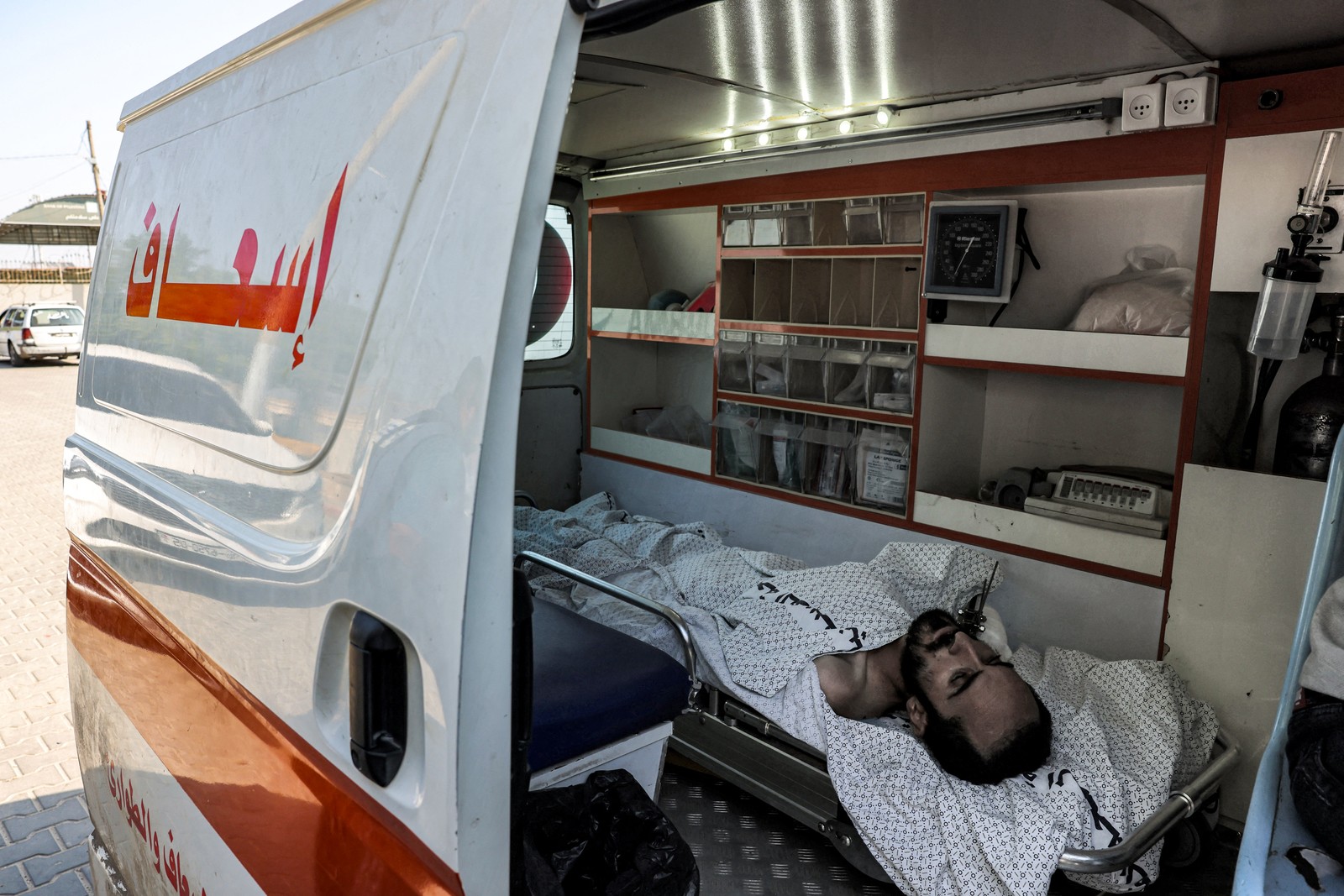 Um homem ferido está dentro de uma ambulância esperando na passagem de fronteira de Rafah — Foto: Mohammed ABED/AFP