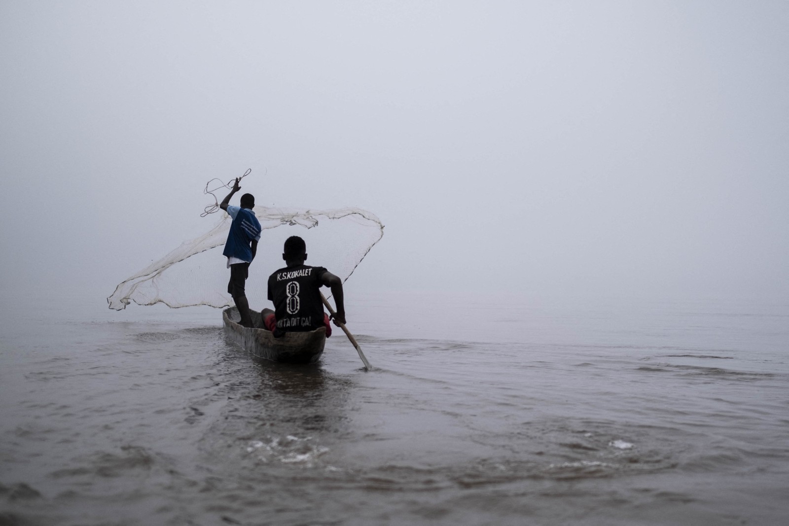 Pacôme Koyeke, presidente da organização de peixeiros da República Centro-Africana, One For All, lança tarrafa no rio, em Bangui, na República Centro-Africana — Foto: BARBARA DEBOUT/AFP