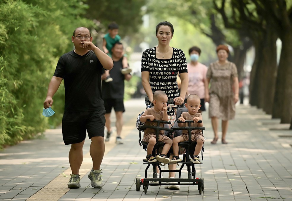 Famílias com bebês caminham em parque de Pequim — Foto: Noel Celis / AFP