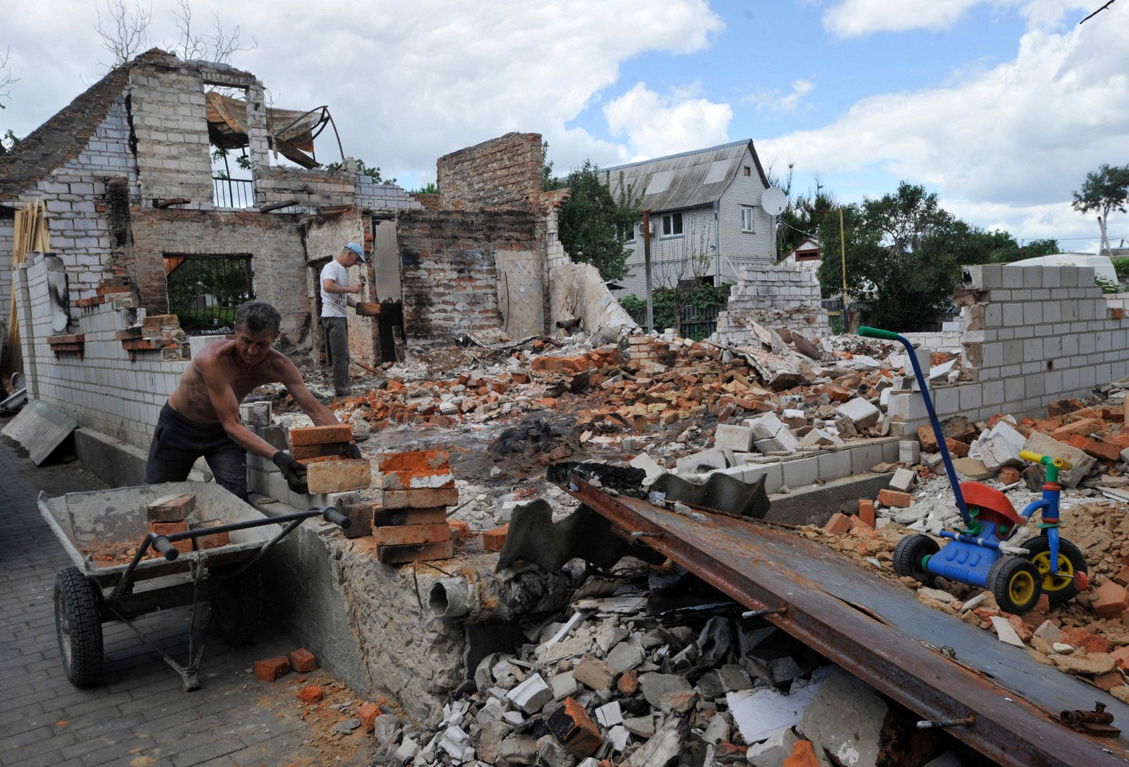 Homem participa da reconstrução de uma casa destruída na pequena cidade de Makariv, região de Kiev, capital da Ucrânia — Foto: SERGEI CHUZAVKOV / AFP