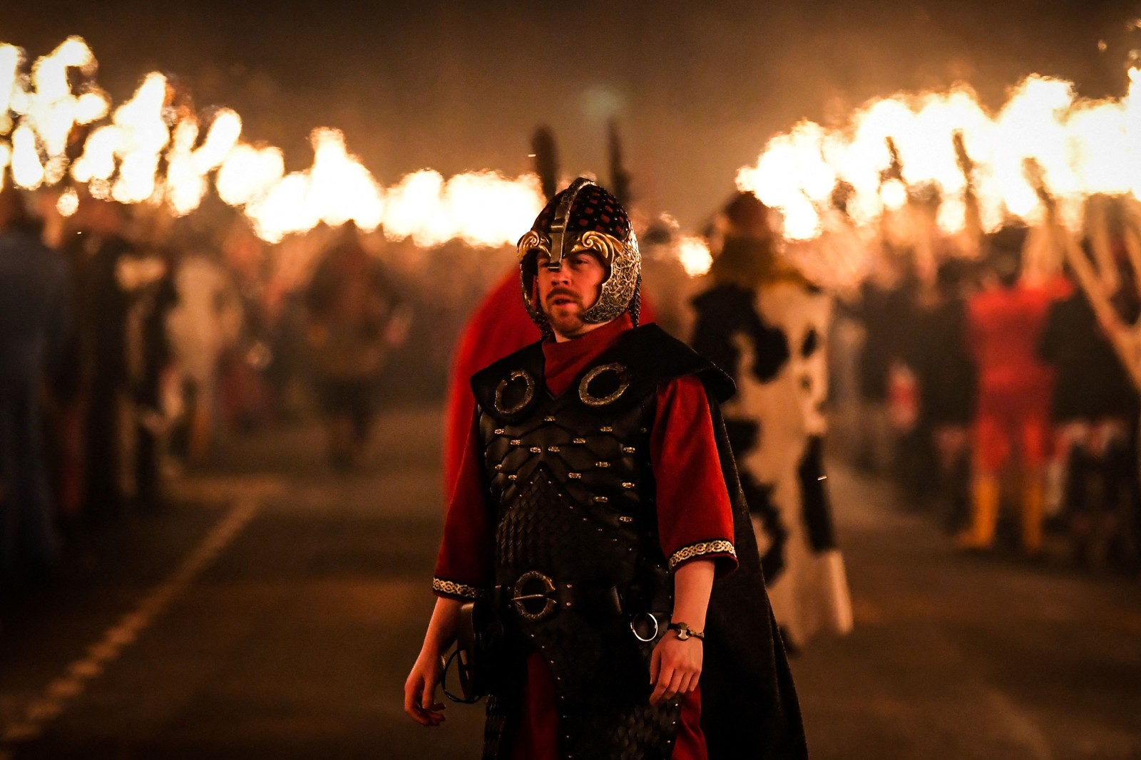 Procissão é liderada pelo Guizer Jarl e culmina com os participantes usando tochas flamejantes para incendiar réplica de navio viking — Foto: Andy Buchanan / AFP 