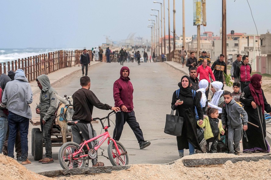 Palestinos deslocados fugindo da área próxima ao hospital al-Shifa chegam pela rodovia costeira ao campo de refugiados de Nuseirat, no centro da Faixa de Gaza, em meio às contínuas batalhas entre Israel e o grupo militante Hamas.