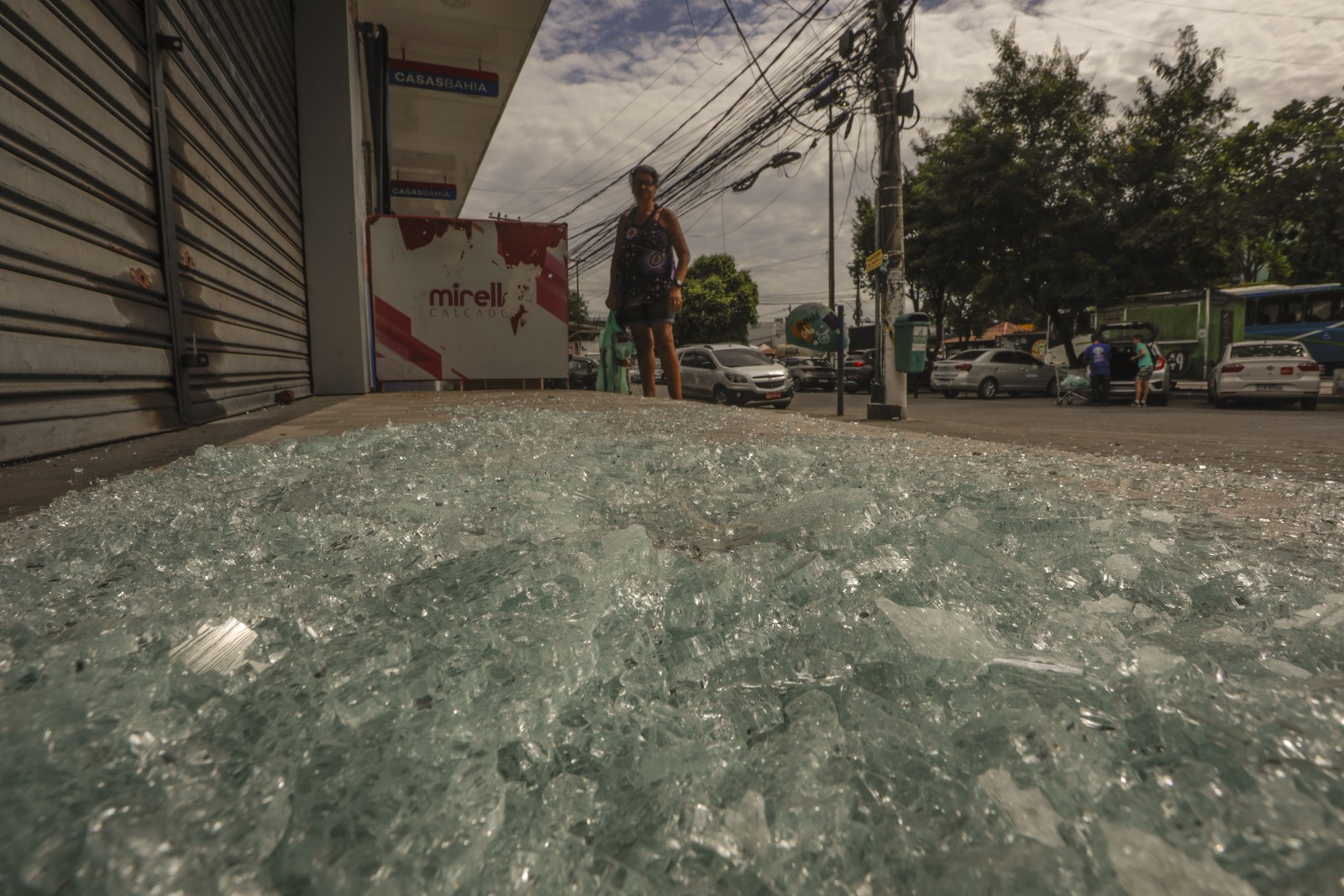 Cacos de vidros espalhados pela rua Ministro Fernando Costa após tiroteio. — Foto: Gabriel de Paiva / Agência O Glbo