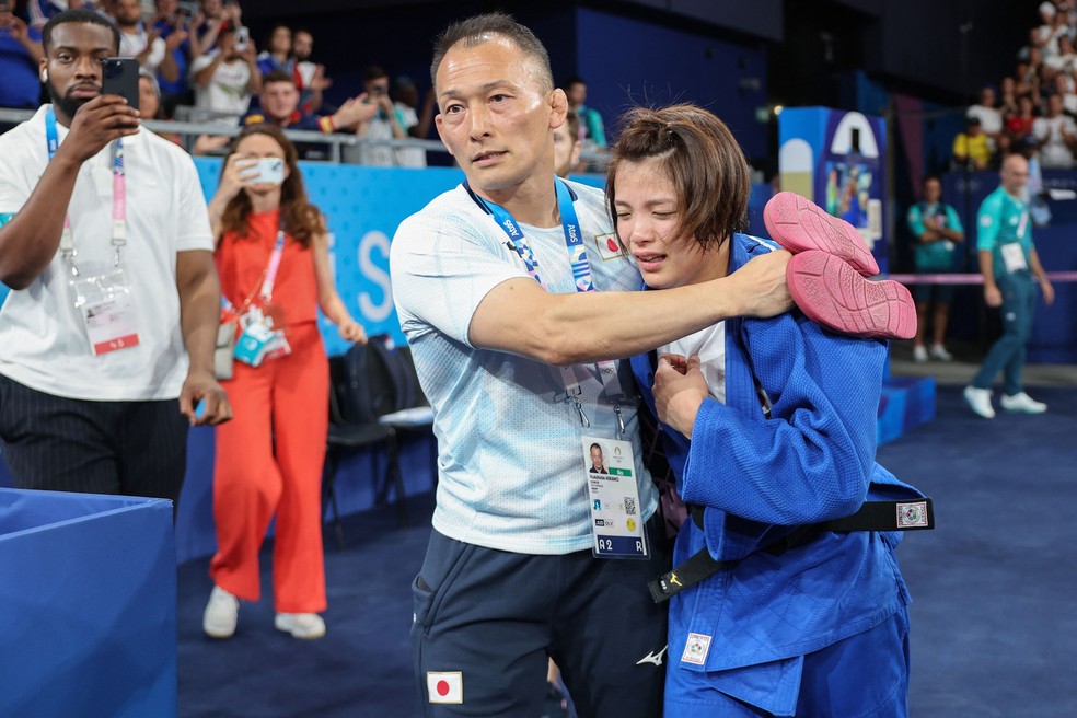 Japonesa Uta Abe é consolada pelo técnico após derrota em Paris-2024 — Foto: Jack GUEZ / AFP