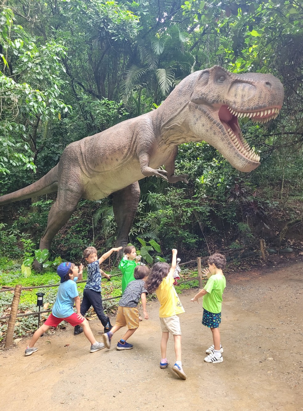 Crianças ao lado da reprodução de um Tiranossauro Rex no parque Terra dos Dinos, em Miguel Pereira, no Estado do Rio — Foto: Eduardo Maia