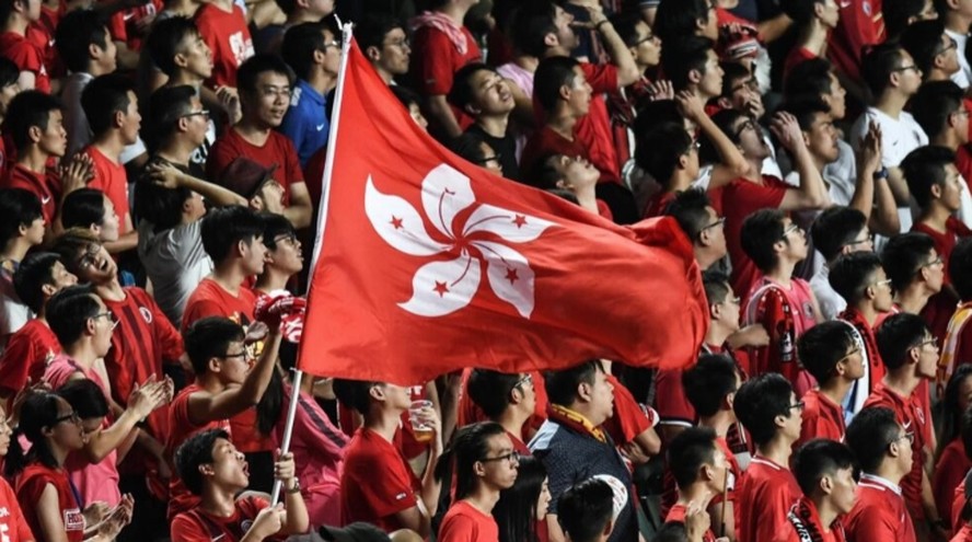 Torcedores de Hong Kong seguram sua bandeira durante uma partida