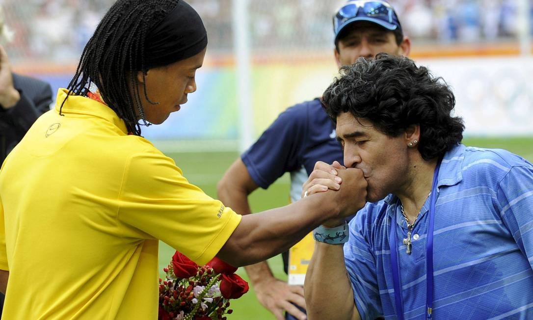 Craque beija a mão de Ronaldinho Gaúcho durante cerimônia de entrega de medalhas de futebol masculino das Olimpíadas de Pequim, em 2008, quando os argentinos conquistaram o ouro na vitória sobre a Nigéria de 1 a 0, com gol de Ángel Di María — Foto: Daniel Dal Zennaro / Arquivo