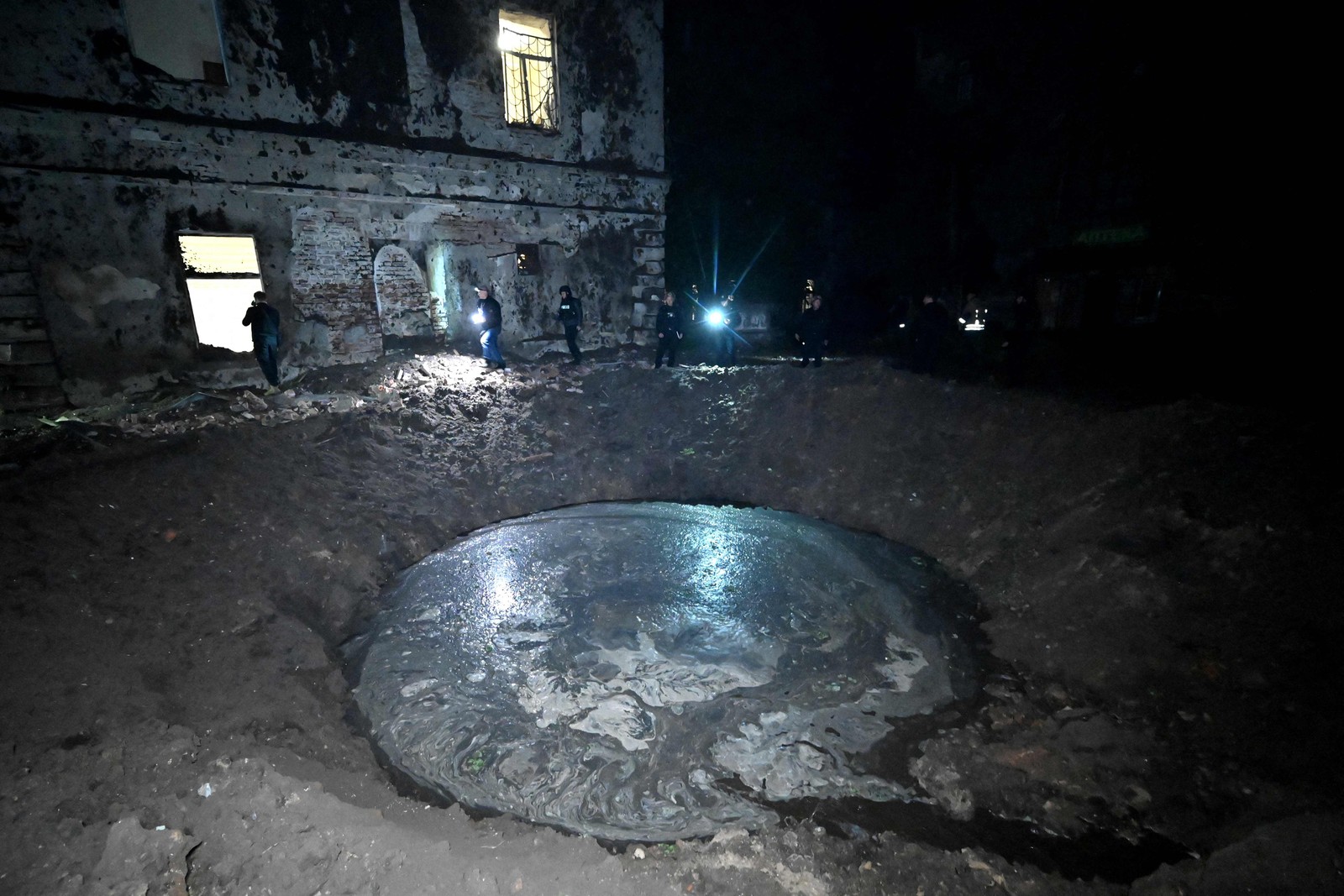 Cratera aberta por bombardeio de míssil russo na região de Kharkiv, na Ucrânia — Foto: Sergey Bobok/AFP